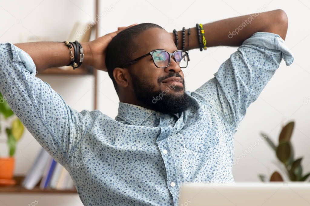 Dreamy African American businessman relaxing after finished work