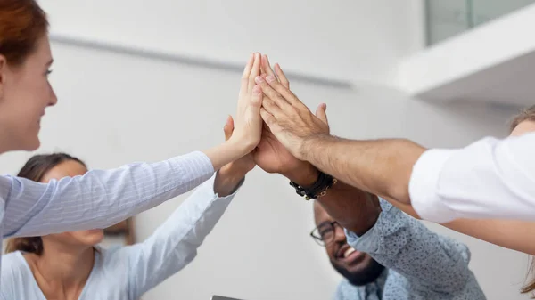 Close up diverse employees team giving high five at company meeting — Stock Photo, Image