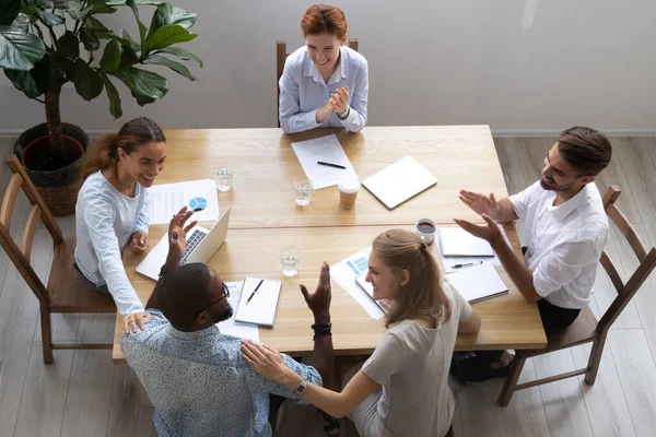 Diverse colleagues congratulating African American colleague with success