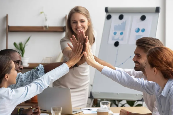 Sonriente líder del equipo con el equipo de empleados dando cinco altos —  Fotos de Stock