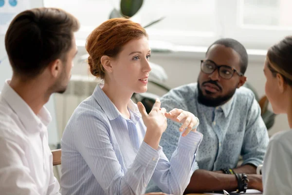 Confident businesswoman discussing project with diverse colleagues at briefing — Stok fotoğraf