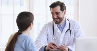 Smiling male doctor wear white medic coat consulting female patient