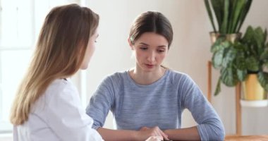 Young female patient listening doctor during medical checkup visit