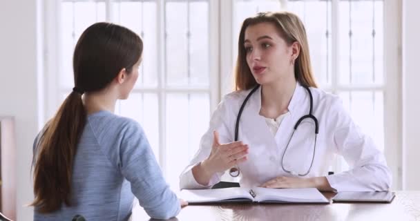 Femme souriante médecin poignée de main jeune femme patiente après consultation médicale — Video