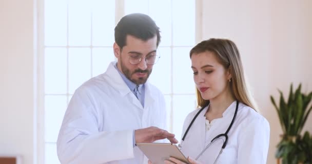 Équipe médicale deux médecins professionnels ayant une discussion utilisent une tablette numérique — Video