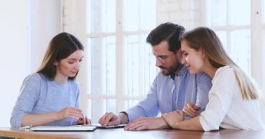 Happy young couple sign mortgage contract get keys handshake realtor