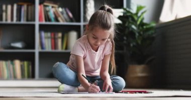 Cute little kid girl drawing colored pencils playing on floor