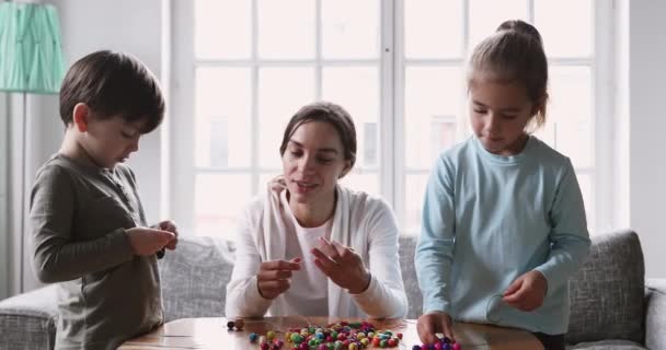 Smiling young mum babysitter and two kids play sensory game — Αρχείο Βίντεο