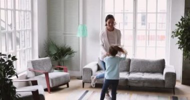 Happy mum and child daughter having fun in living room