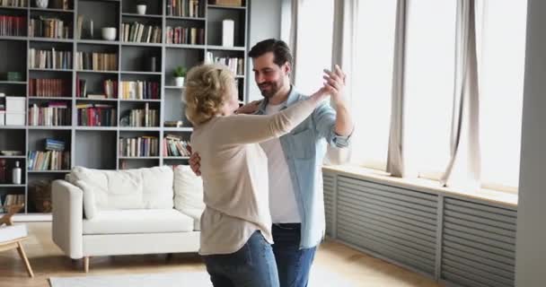 Happy young adult son enjoying slow dance with mature mother — 图库视频影像