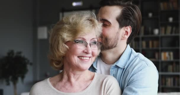 Caring adult son hugging kissing happy older mom expressing affection — Wideo stockowe