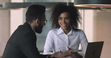 Young african ethnicity office worker nodding, agreeing with arabian coworker.