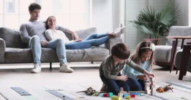 Kids playing while relaxed parents lounge in living room interior