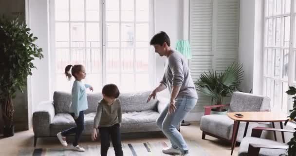 Cute kids imitate father funny moves dancing in living room — Stock video