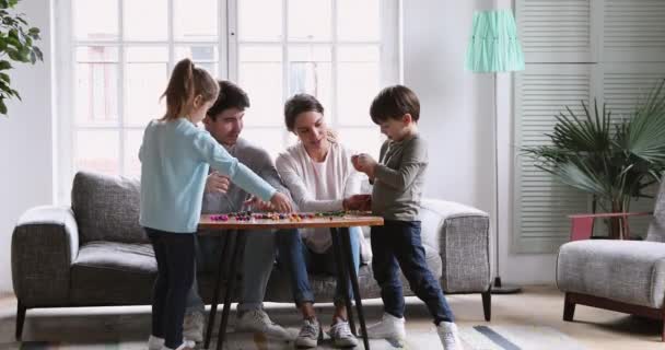 Jovens pais felizes brincando com crianças fazem atividade de artesanato criativo — Vídeo de Stock