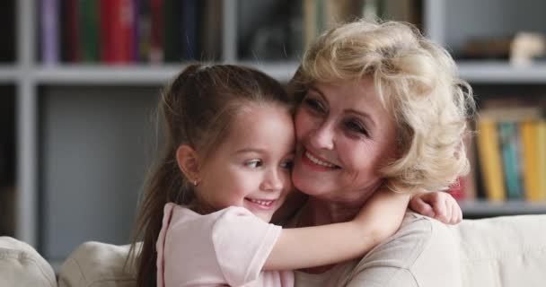 Tender affectionate older grandma hugging cute little granddaughter bonding cuddling — Αρχείο Βίντεο