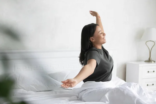 Wanita birasial yang gembira bangun di tempat tidur peregangan — Stok Foto