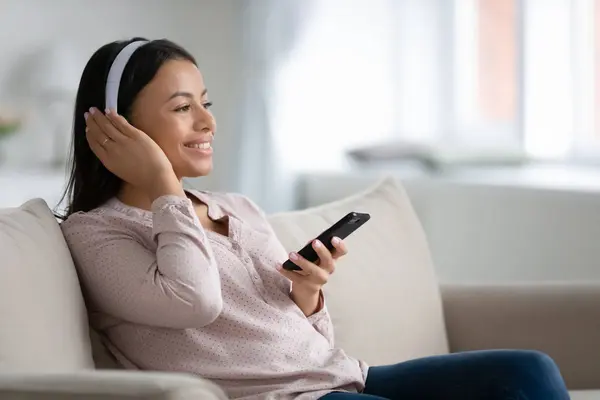 Happy biracial vrouw in hoofdtelefoon genieten van muziek op de smartphone — Stockfoto