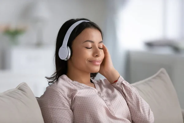 Afro-Amerikaanse vrouw in hoofdtelefoon genieten van muziek — Stockfoto