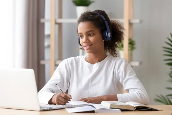 African girl wearing headphones study with skype teacher on laptop — Stock Photo, Image