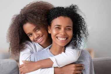 Mutlu Afrikalı aile annesi ve genç kız annesini kucaklıyor, portre