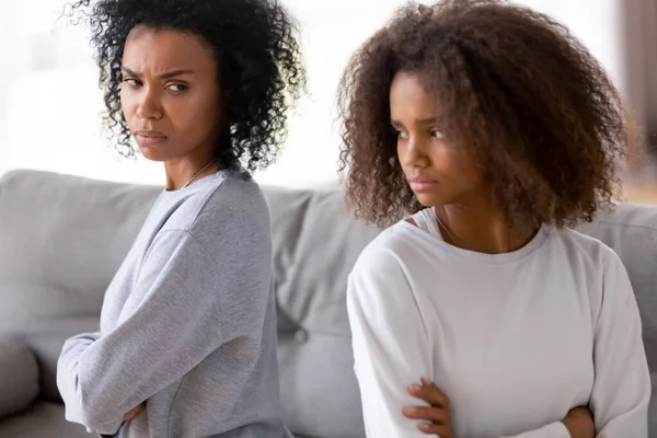 Angry stubborn african mother and teen sitting back turned away — Stock Photo, Image