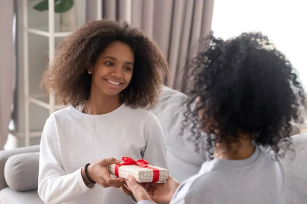 Happy african teen fille donner boîte cadeau d'anniversaire à maman — Photo