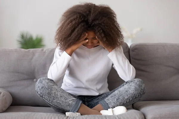 Депрессивная расстроенная африканская девочка-подросток чувствует боль, сидя в одиночестве — стоковое фото