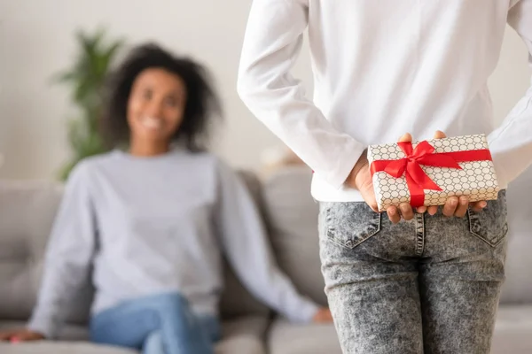 Rear view of teen african daughter holding gift behind back — Stock Photo, Image