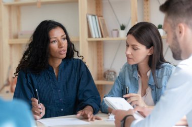 Yoğunlaştırılmış çeşitli meslektaşlar ofiste çalışma sorunlarını tartışıyor.