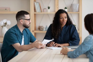 Odaklanmış genç Afro-Amerikan bayan yönetici takım arkadaşlarıyla toplantı yapıyor..