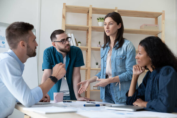 Сосредоточенные молодые сотрудники слушают мотивированных квалифицированных женщин-профессионалов
.