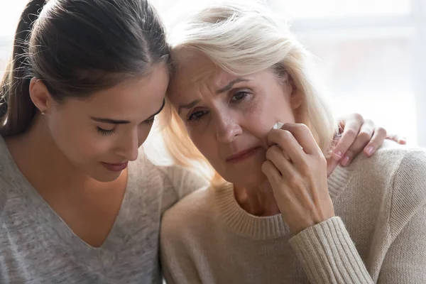 Close up young grown up worried daughter hugging frustrated mother. — Stock Photo, Image