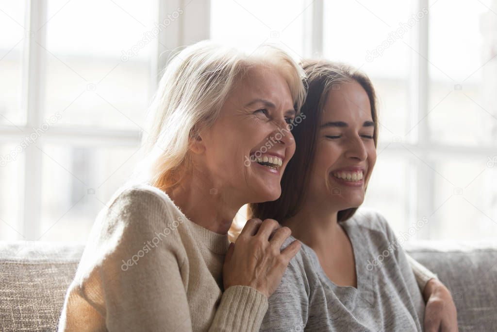 Overjoyed senior mother hugging happy grown up adult daughter.