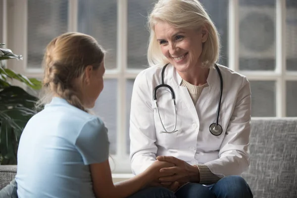 Rare view little school girl visiting smiling female pediatrician at clinic. — Stock Photo, Image