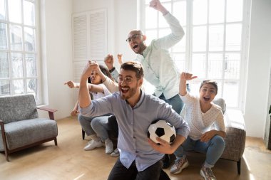 Heyecanlı çoklu etnik arkadaşlar içeride futbol zaferini kutluyor.