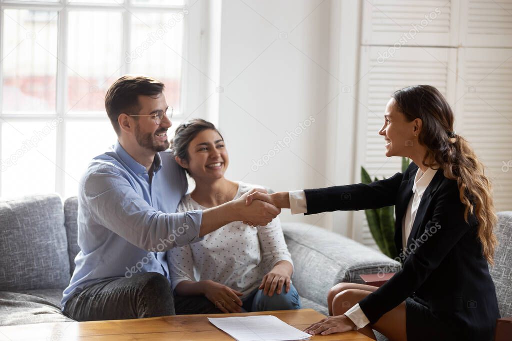 Realtor handshaking with couple after signing rental agreement