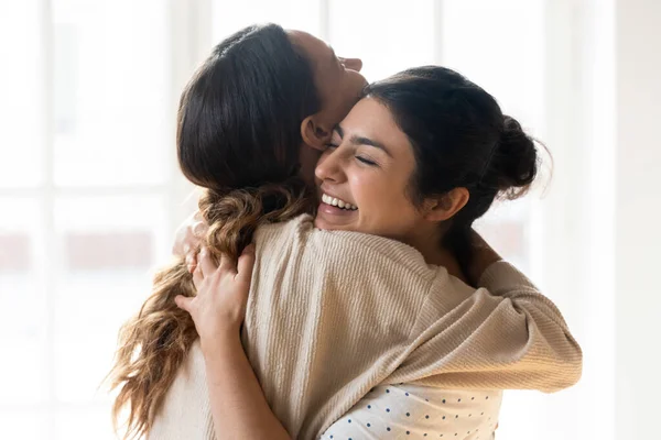 Chicas multirraciales sinceras mejores amigos abrazando de pie en el interior — Foto de Stock