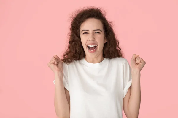 Giovane donna felicissima stringendo pugni, celebrando il successo . — Foto Stock