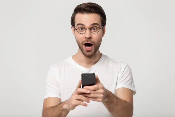 Fantastisk glad kille håller mobiltelefon, fick oväntade vinna nyheter. — Stockfoto