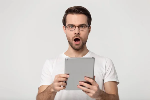 Surprised young man holding digital tablet, received unbelievable news. — 스톡 사진