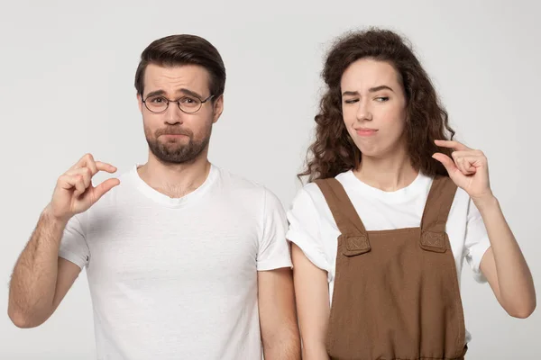 Funny family couple showing small measurement with fingers. — Stock Photo, Image