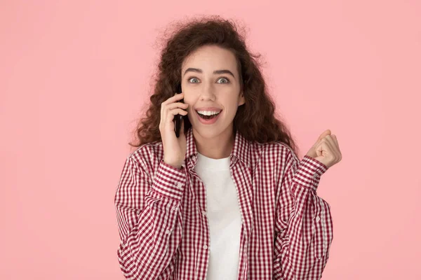 Astonished happy millennial lady talking on cellphone, listening amazing news. — Stockfoto