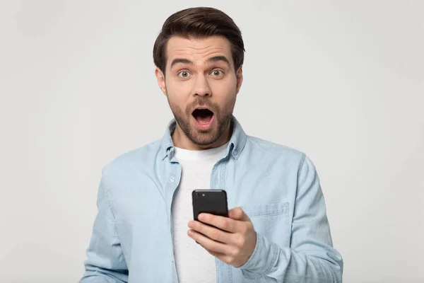 Positively surprised excited young guy received unexpected news via sms. — 스톡 사진