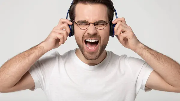 Head shot studio portrait overjoyed young guy wearing wireless headphones. — Stock Photo, Image