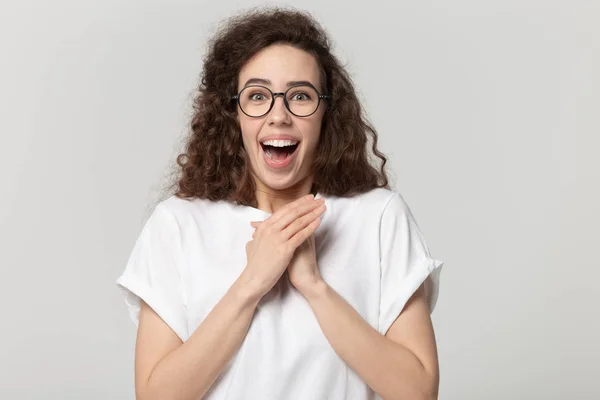 Surprised attractive young woman holding hands together, screaming with joy. — Stockfoto