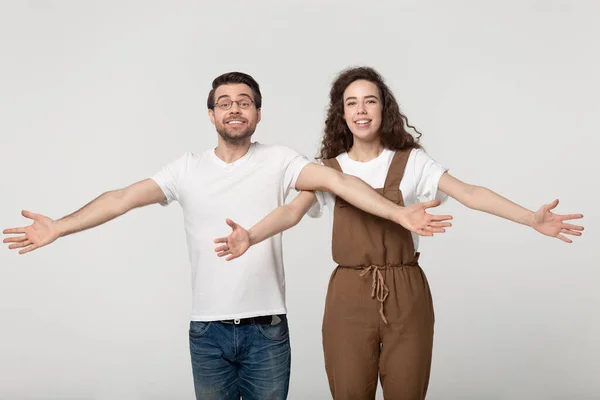 Excited smiling millennial couple welcoming clients, happy to see friends. — Stok fotoğraf