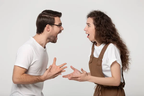 Aggressive stressed young couple arguing in front of each other. — Stok fotoğraf