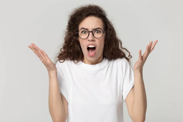 Millennial woman in eyeglasses feeling anger, annoyed by bad news. — Stockfoto