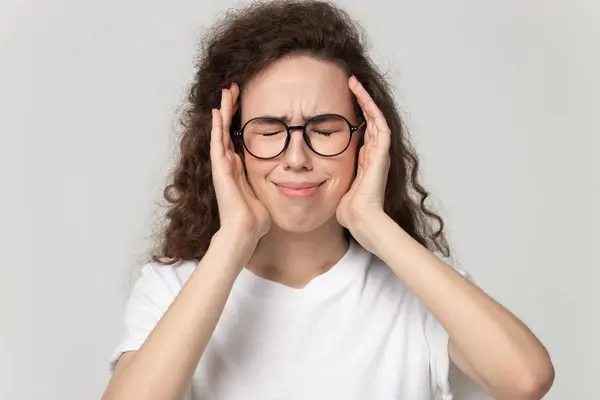 Stressed young girl in eyeglasses suffering from strong head ache. — Stock Photo, Image